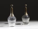 une paire de vases en argent et en verre posés sur une table, sur fond noir