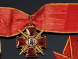 a red ribbon with a gold cross and a star on it