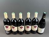 six bottles of wine lined up in a row on a table