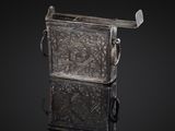an old silver metal box with a handle on a black background