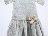 baby girl ' s dress hanging on a hanger with a bow