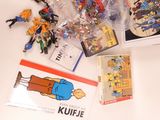 a lot of action figures and books on the table