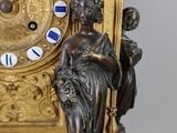 a gold clock with blue and white roman numerals on it