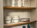 many dishes and glasses on the shelves in the kitchen