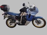 une moto bleue garée sur une surface grise