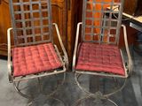 une paire de chaises en métal avec des coussins rouges dans une pièce aux murs orange