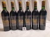 six bottles of wine are lined up in a row on a table