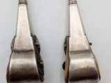 pair of silverware spoons on a white surface with a white background