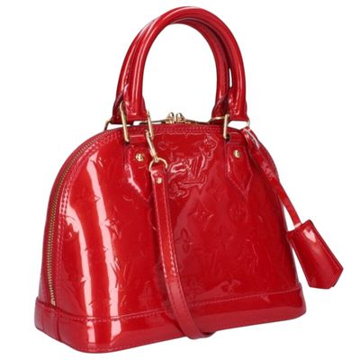 a red handbag with gold hardware on the handle