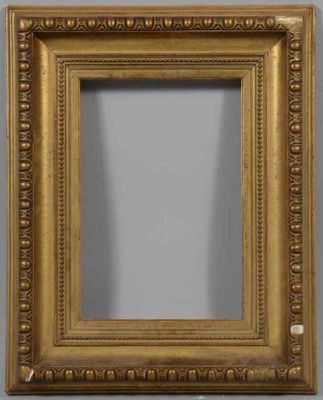 un miroir à cadre doré orné d'un motif décoratif, accroché au mur