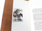 an open book with a picture of a mountain on it