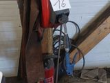une borne d'incendie rouge posée dans un garage, à côté d'un tas de bois