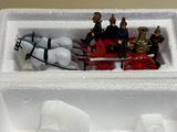 toy figurines of people riding in a carton with a horse drawn carriage
