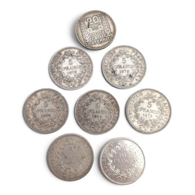 six types différents de pièces d'argent sur une surface blanche