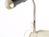 a black lamp that is on a desk next to a white wall