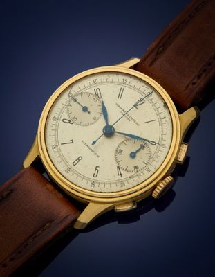 a close up of a gold wrist watch with a brown leather strap