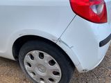 a small white car parked on the side of the road