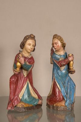 two figurines of two women holding wine glasses on a table