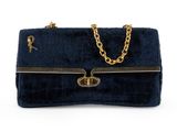a blue velvet handbag with gold chain handles and a chain strap