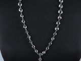une femme portant un haut noir et un collier orné d'un pendentif en argent