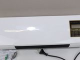 a white air conditioner sitting on top of a table next to a charger