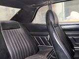 the interior of a car with black leather seats and a wooden block