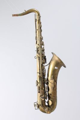 an old brass saxophone on a stand against a white background