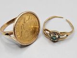 two gold rings with a coin on top of them