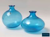 two blue vases sitting next to each other on a table