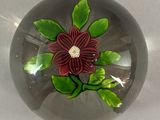 a glass ball with a flower on it on a table