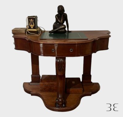 une statue de femme assise sur une table à côté d'une horloge
