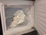 an open refrigerator with a bag of food inside of it
