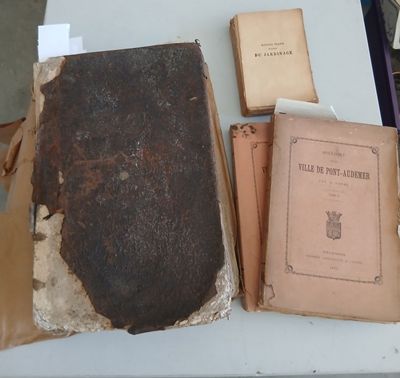 many old books on a table with papers on top of them