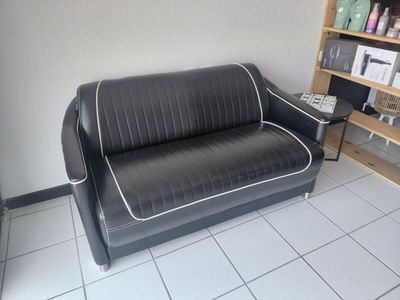 a black and white couch in a room with a book shelf