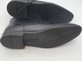 black leather shoes with laces on the soles on a white surface