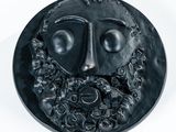 une image représentant une assiette noire sur laquelle figure le visage d'un homme