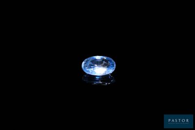 a close up of a blue sapphire on a black surface