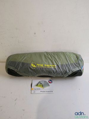 a sleeping bag on a white surface with a tag