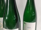 three bottles of wine are lined up on a white surface