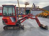 a small red excavator that is parked in a parking lot