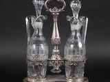 three glass vases that are on a silver stand
