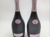 deux bouteilles de vin rosé posées l'une à côté de l'autre sur une surface blanche
