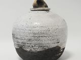 un vase noir et blanc posé sur une table blanche