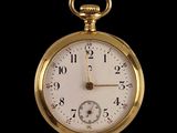 a close up of a gold pocket watch on a black background