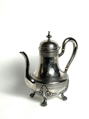 silver plated tea pot on stand on white surface with white background