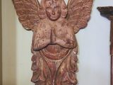 a statue of an angel on the wall next to a clock