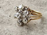 an image of a gold ring with a cluster of diamonds on it