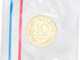 a close up of a coin in a clear bag with a red, white, and blue stripe