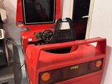une voiture rouge avec un volant et une télévision dans un coin