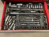 a red tool box filled with various tools on the floor